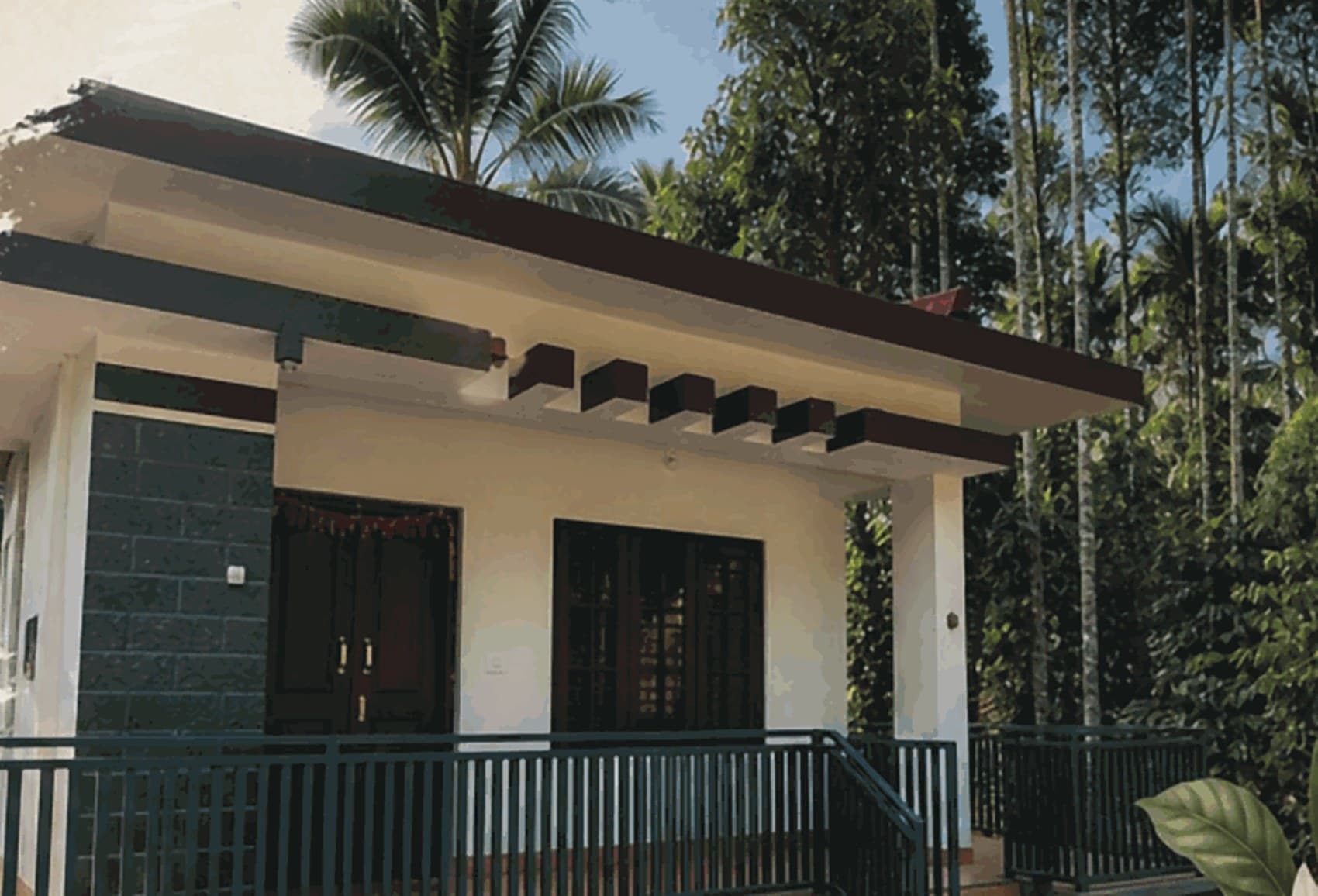 The house at Nadithaara, verandah and railing, areca palms behind