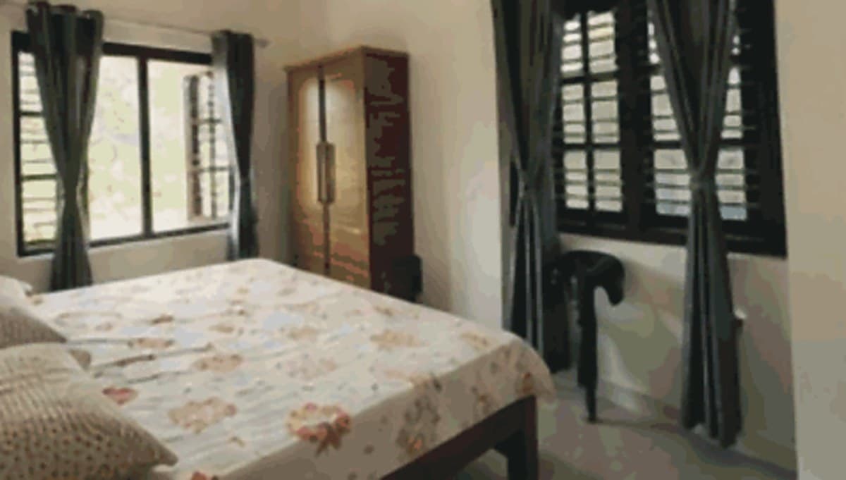 Room One at Nadithaara, two double beds and a window onto the estate